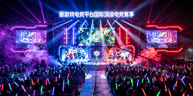 爱游戏电竞平台举办的国际顶级电竞赛事现场，座无虚席的观众与绚丽的舞台灯光